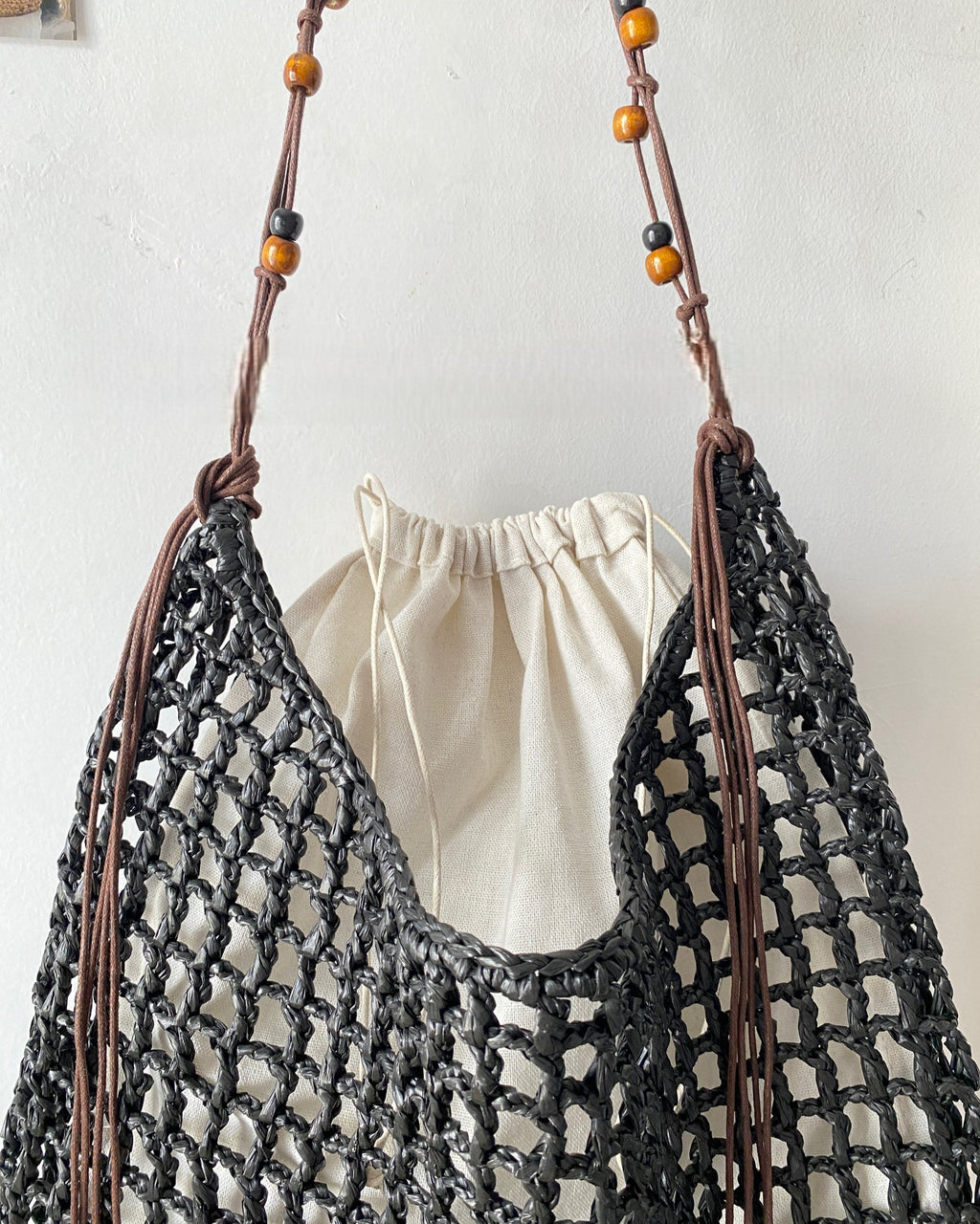 Wildfool Beaded Grass Tote in Black — three-quarter view, strap over shoulder