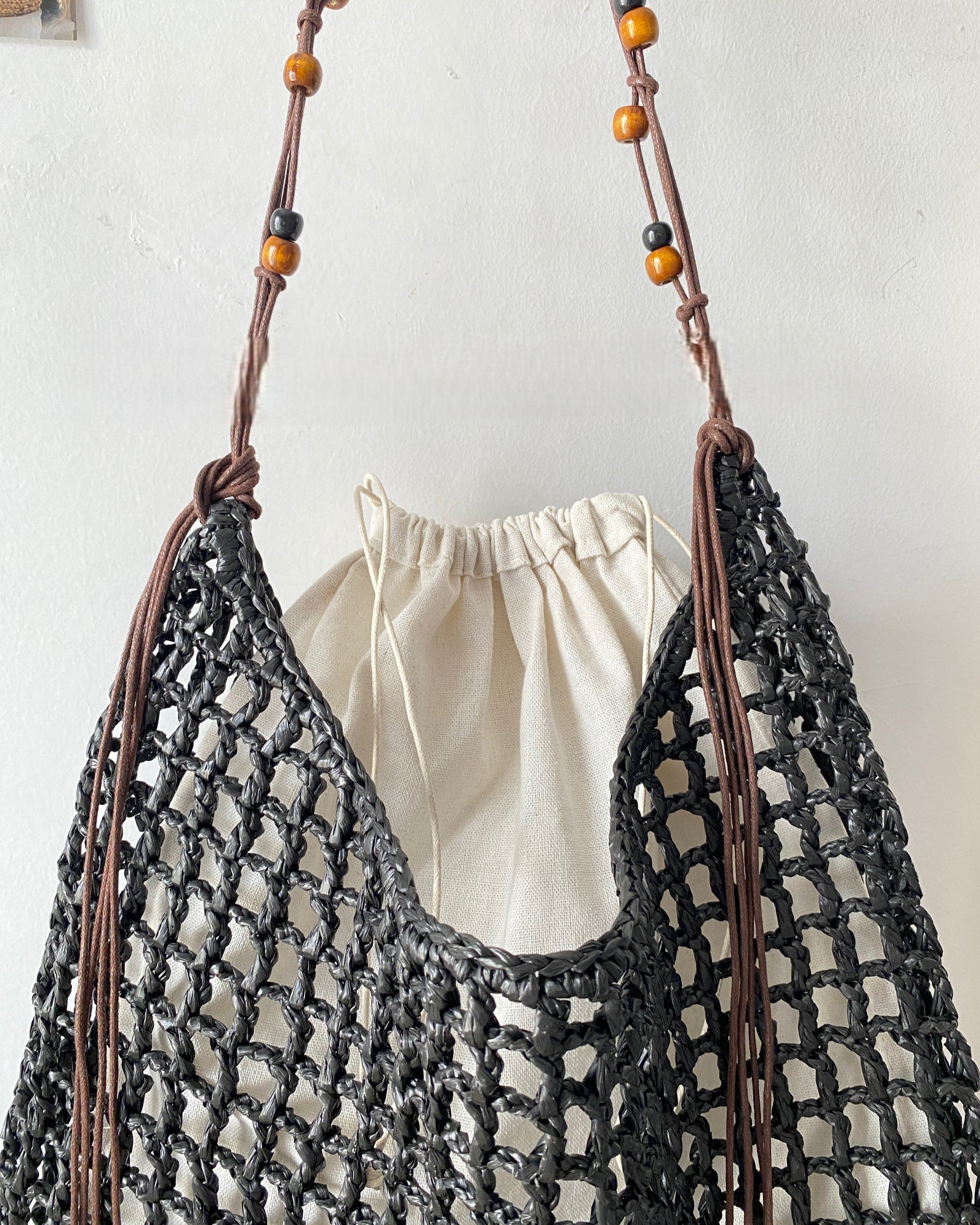 Wildfool Beaded Grass Tote in Black — three-quarter view, strap over shoulder
