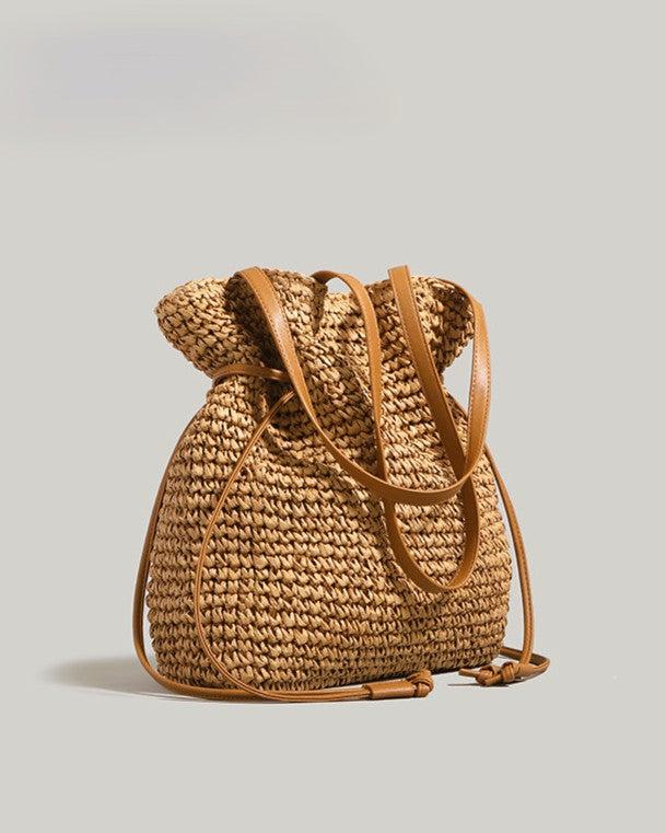 Khaki straw bucket bag filled with market produce — lifestyle overhead shot