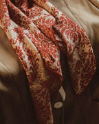 Detail of curled vine and unfurled leaf baroque pattern on silk wool blend surface