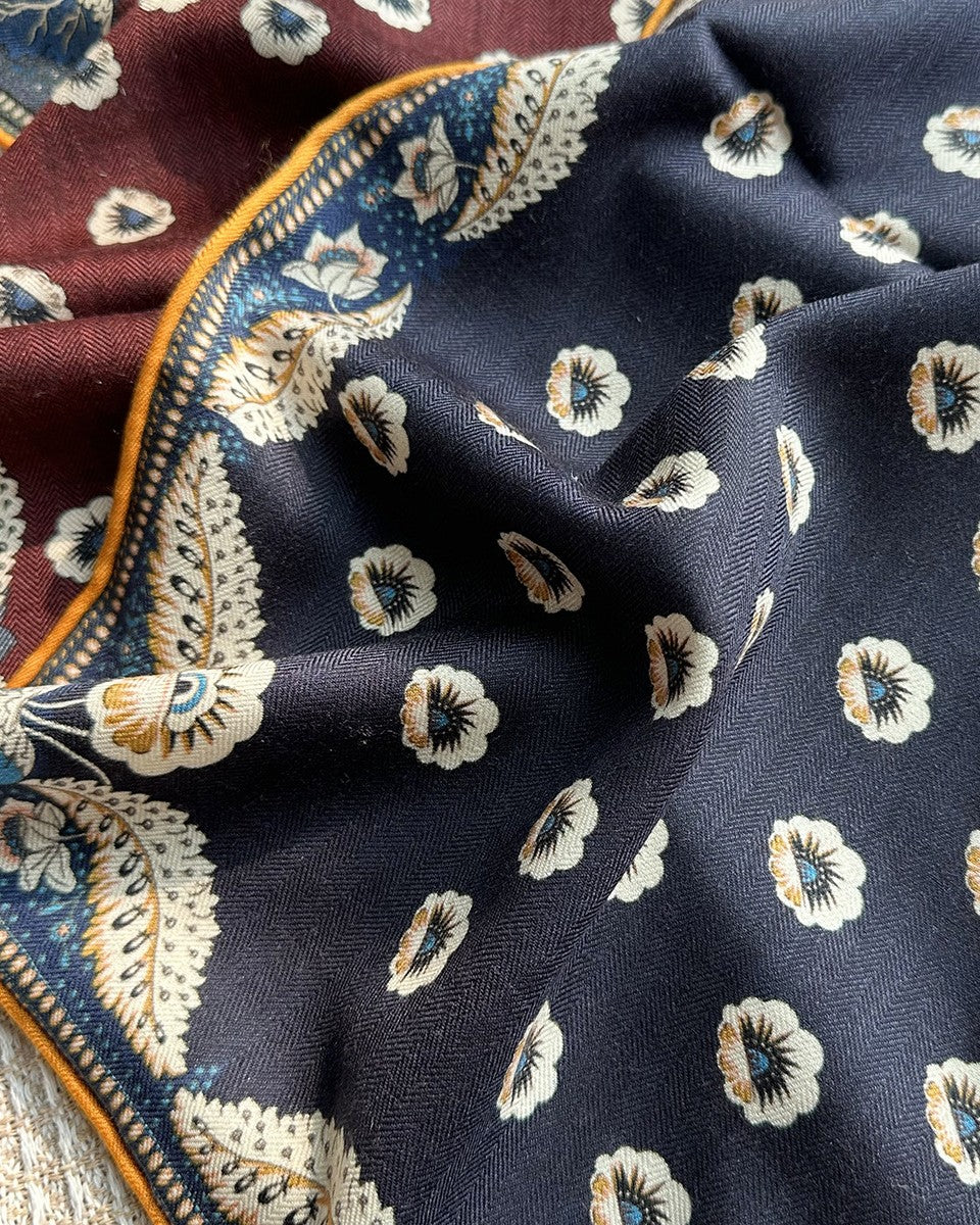 Wildfool red-blue scarf knotted at neck showing three-color layering of wine, navy, and gold