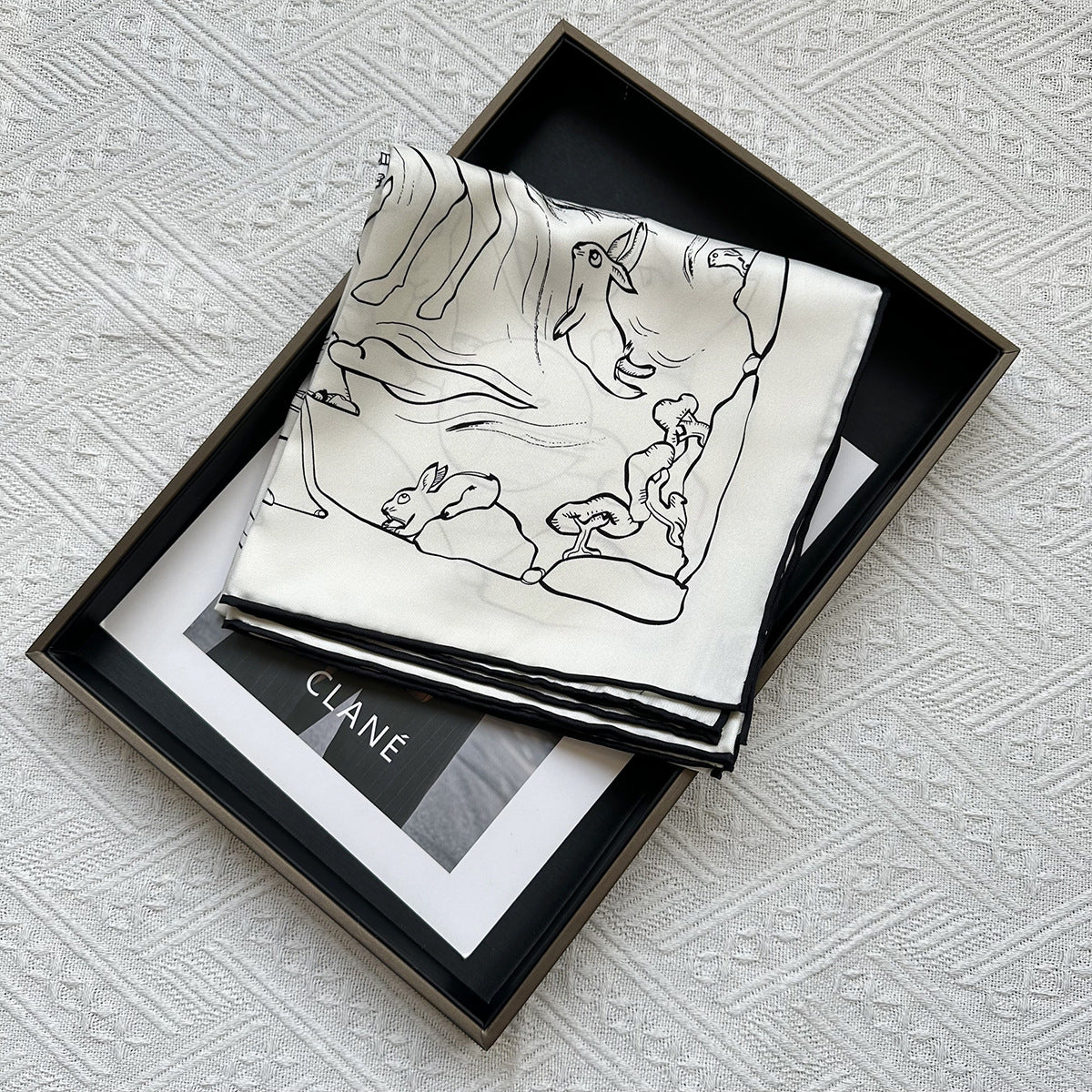 Wildfool silk scarf with rabbit print — folded as triangle headscarf, natural outdoor light