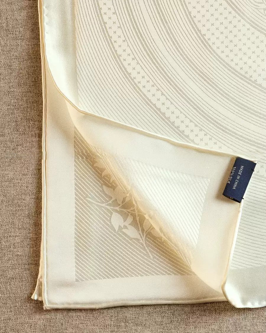 Wildfool solid ivory silk scarf knotted at neck over black top showing gravity drape