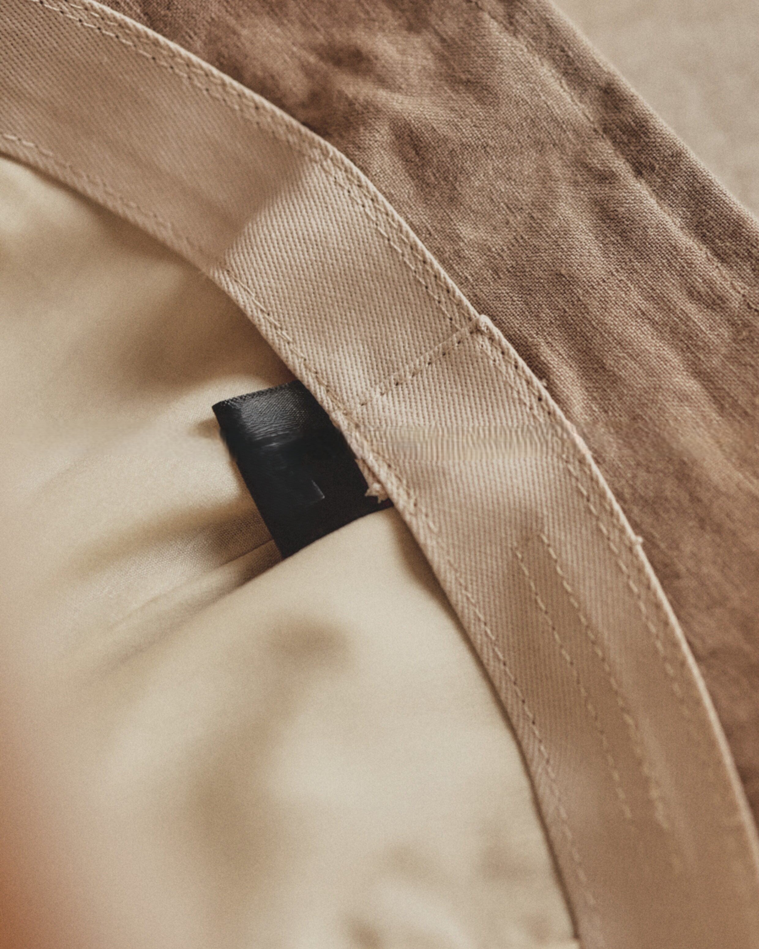 Wildfool Washed Linen Docker Cap in Black — three-quarter view showing minimal brim