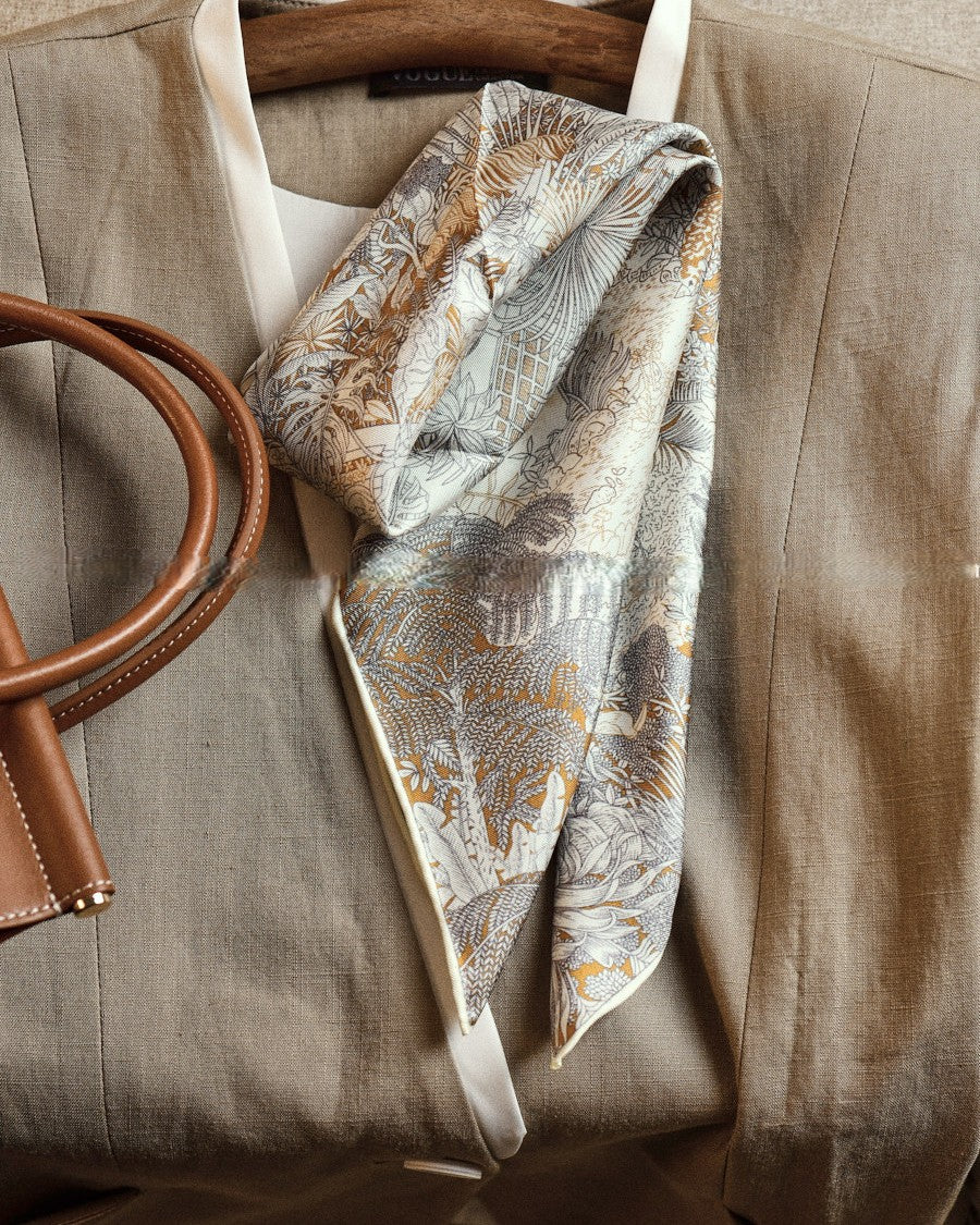 Wildfool silk wool reversible scarf showing gold tropical botanical side — flat lay on linen