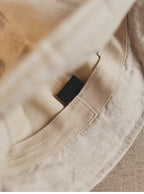 Wildfool Washed Linen Docker Cap in Black — three-quarter view showing minimal brim