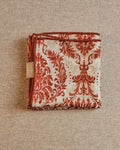Close-up of mirrored baroque vine and petal detail on Wildfool red silk wool scarf