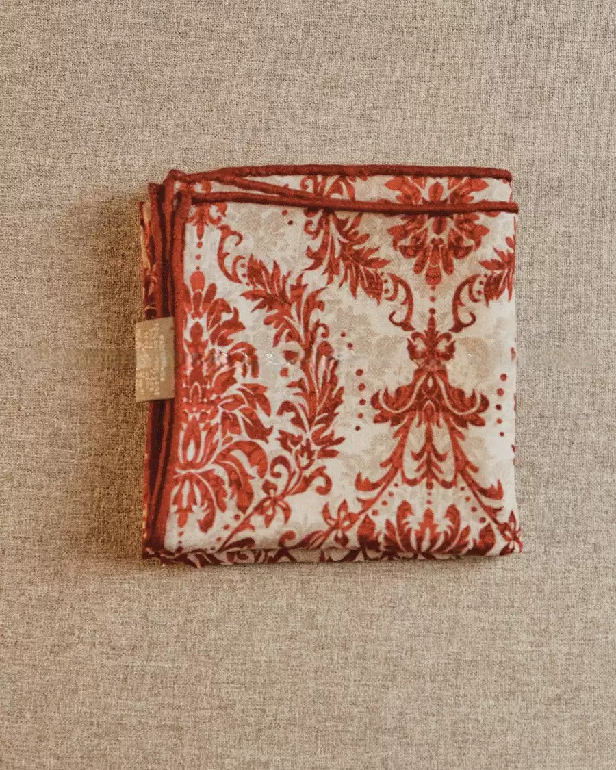 Close-up of mirrored baroque vine and petal detail on Wildfool red silk wool scarf