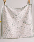 Close-up of subtle stirrup and rein patterns in gray-sage against cream silk lace weave