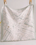 Close-up of subtle stirrup and rein patterns in gray-sage against cream silk lace weave
