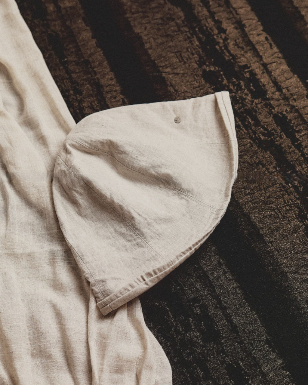 Wildfool Washed Linen Docker Cap in Black — three-quarter view showing minimal brim