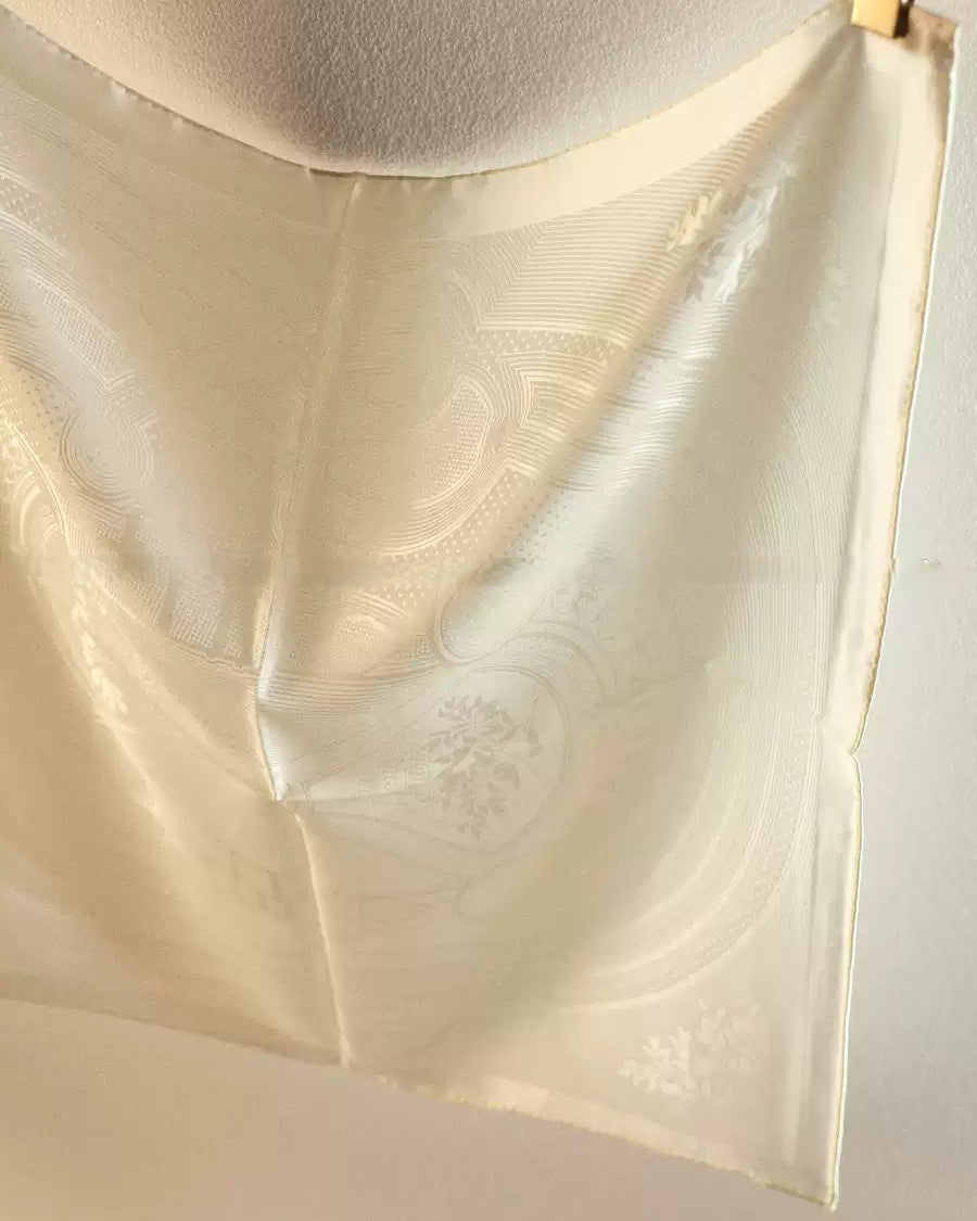 Close-up of hidden jacquard wave pattern visible under light on Wildfool ivory silk scarf