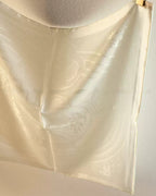 Close-up of hidden jacquard wave pattern visible under light on Wildfool ivory silk scarf