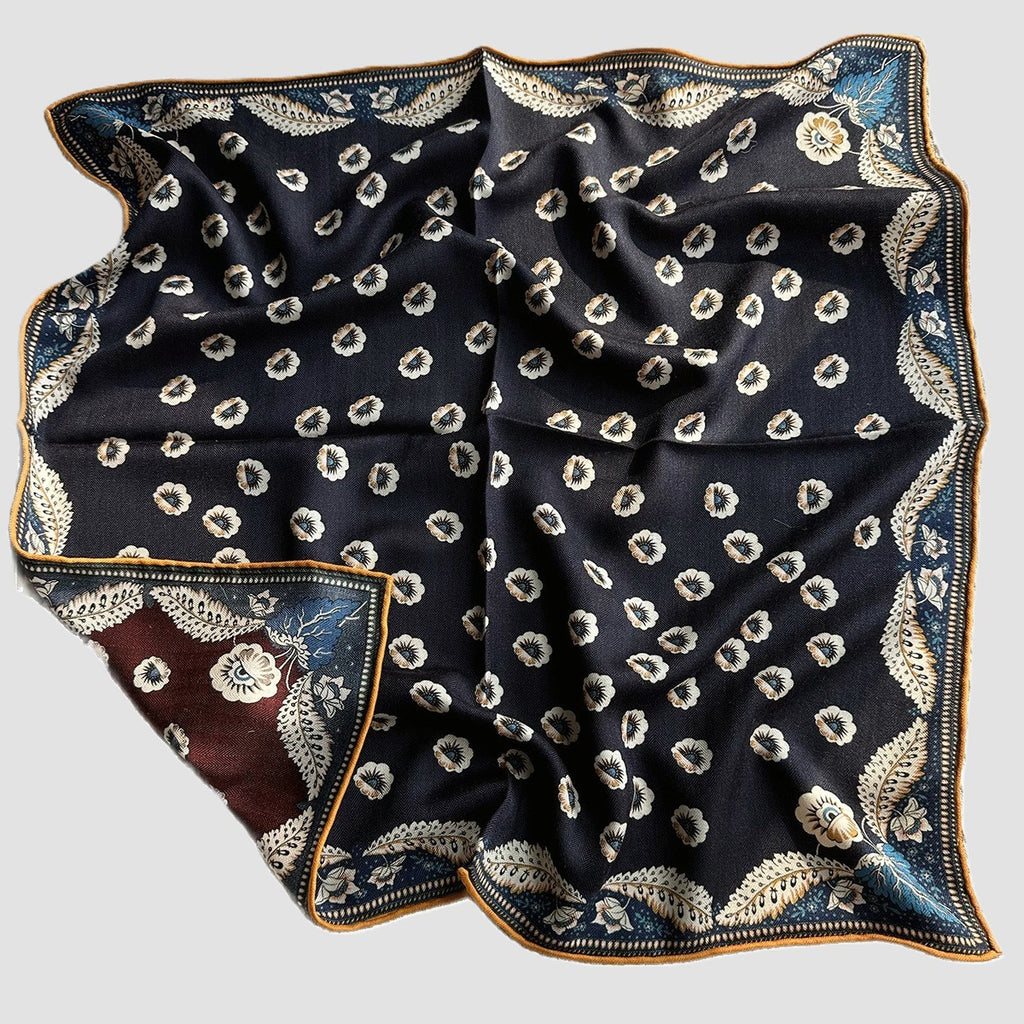 Navy reverse side of Wildfool scarf showing ornate gold curled-vine border detail