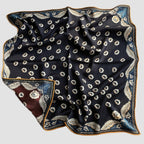 Navy reverse side of Wildfool scarf showing ornate gold curled-vine border detail