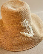 Wildfool Raffia Tulip Sun Hat in Honey — close-up of white shell petal accent
