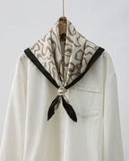 Flat lay of folded scarf showing continuous flow of organic lines and hand-rolled edge detail