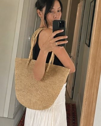 El bolso de mano de rafia tejido a mano
