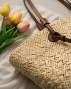 Cream basket tote styled with linen shirt — lifestyle flat lay with produce and novel