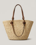 Woman carrying Wildfool cream basket tote over shoulder — farmer's market scene