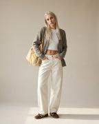 Black woven tote carried on shoulder — lifestyle shot