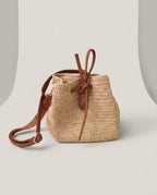Wildfool The Noto Raffia Bucket in Natural — hand-woven raffia bucket bag with leather tie and cowhide strap
