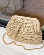 Camel straw bag with brass chain catching evening light — lifestyle shot
