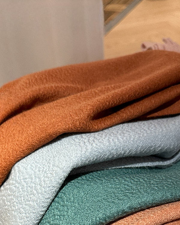 The Dune 100% Cashmere Scarf detail, three scarves folded and stacked