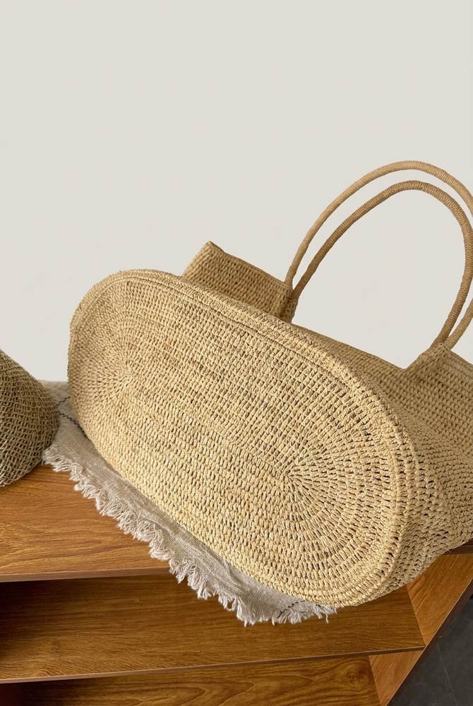 Round hand-woven base of The Florence raffia tote, oval flat-bottom construction