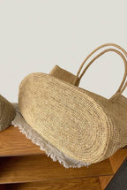 Round hand-woven base of The Florence raffia tote, oval flat-bottom construction