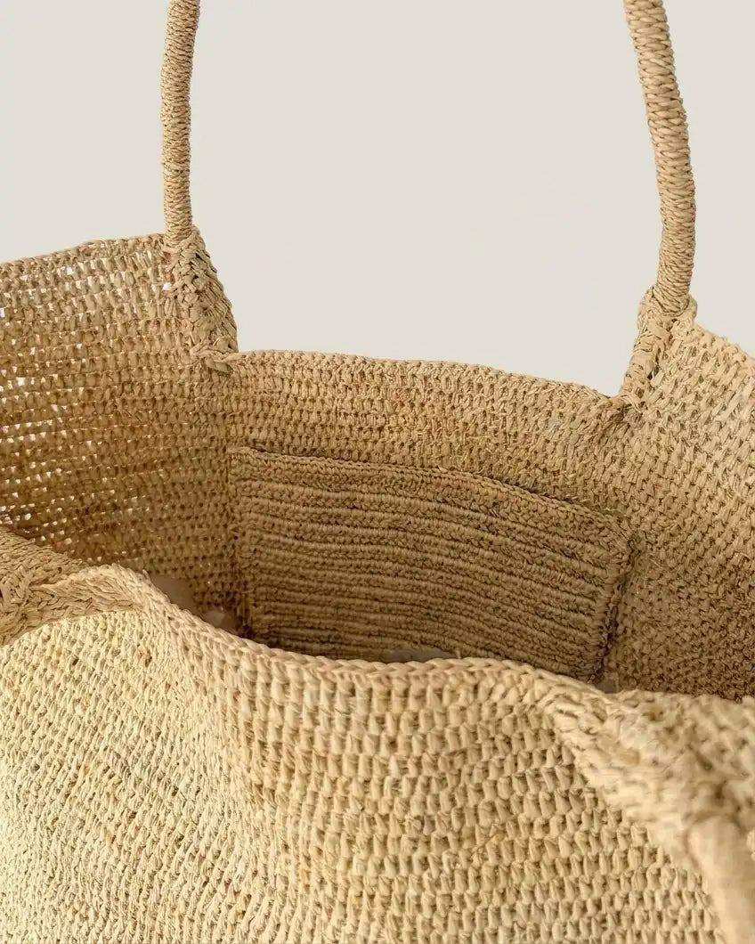 Interior of The Florence raffia tote with hand-woven inner pocket detail for cards