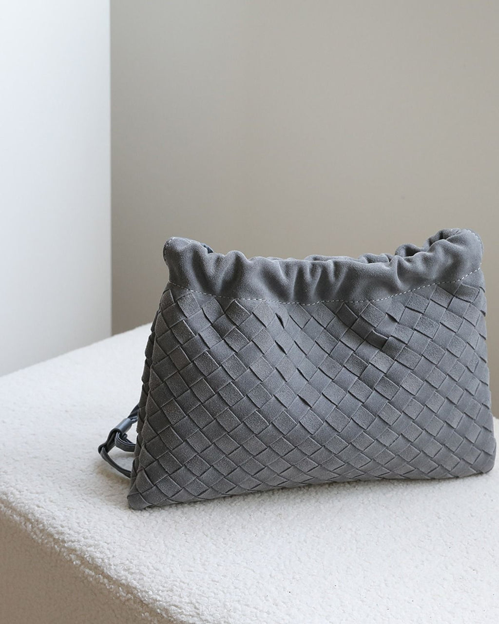Wildfool The Mantova Drawstring Pouch in Grey, on a stone plinth