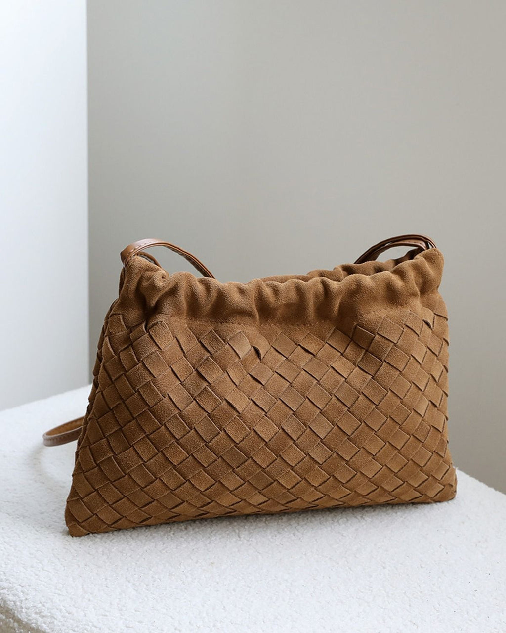 Wildfool The Mantova Drawstring Pouch in Caramel, on a stone plinth