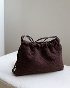 Wildfool The Mantova Drawstring Pouch in Espresso, on a stone plinth