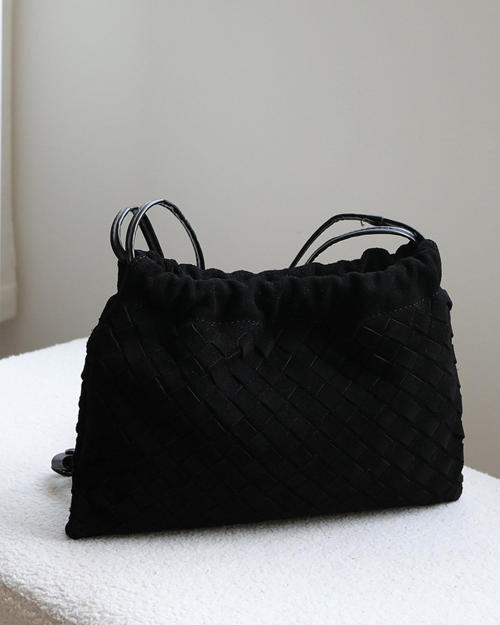 Wildfool The Mantova Drawstring Pouch in Black, on a stone plinth