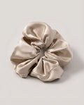 30-momme silk scrunchie set in three colors — champagne, blush, ink — arranged in a row