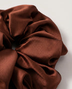Wildfool 30-momme mulberry silk scrunchie in ink black — front view on cream linen