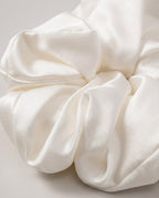 Hand holding the 30-momme silk scrunchie to show its plush volume and weight