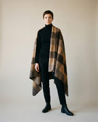830g wool blanket draped over a leather armchair — lifestyle living-room shot in evening light
