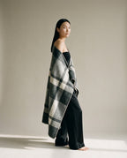 Nomad twill wool blanket draped over shoulders at a campsite — lifestyle outdoor shot
