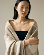 Hand folding the nomad wool blanket into a compact roll for travel