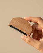 Wildfool beechwood cashmere care comb — full flat lay on cream linen showing wood grain