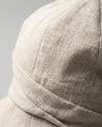 Side profile of Wildfool linen bucket hat with the brim shaped one side up