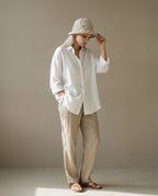 Rolled-brim linen hat worn on model — three-quarter portrait in afternoon city light