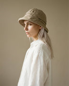 Wildfool rolled-brim linen hat worn with a silk blouse — flat lay styling