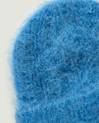 Hand holding Wildfool alpaca beanie to show its barely-there weight