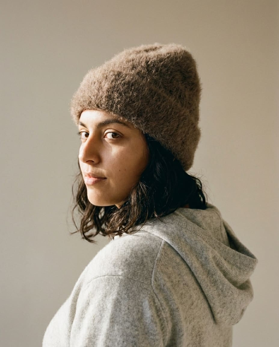 Model adjusting the alpaca beanie at the temple — lifestyle motion shot