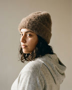 Model adjusting the alpaca beanie at the temple — lifestyle motion shot