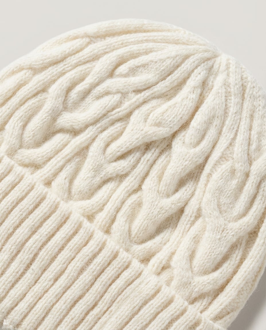Back of head view — Wildfool cable-knit wool beanie on model in winter coat