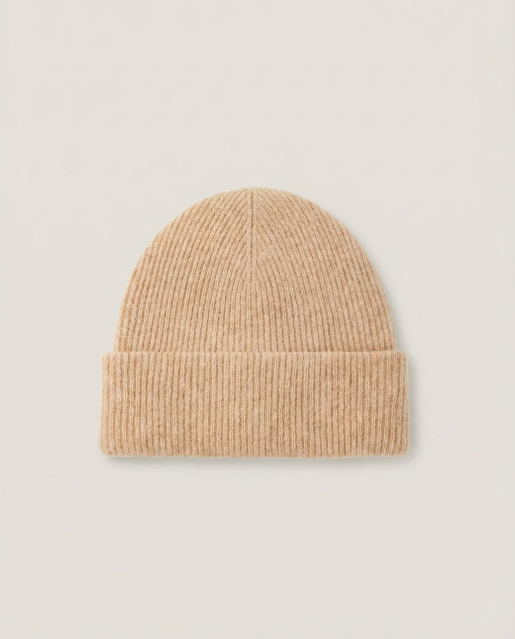 Model pulling the cashmere-blend beanie down over the ears in cold morning light